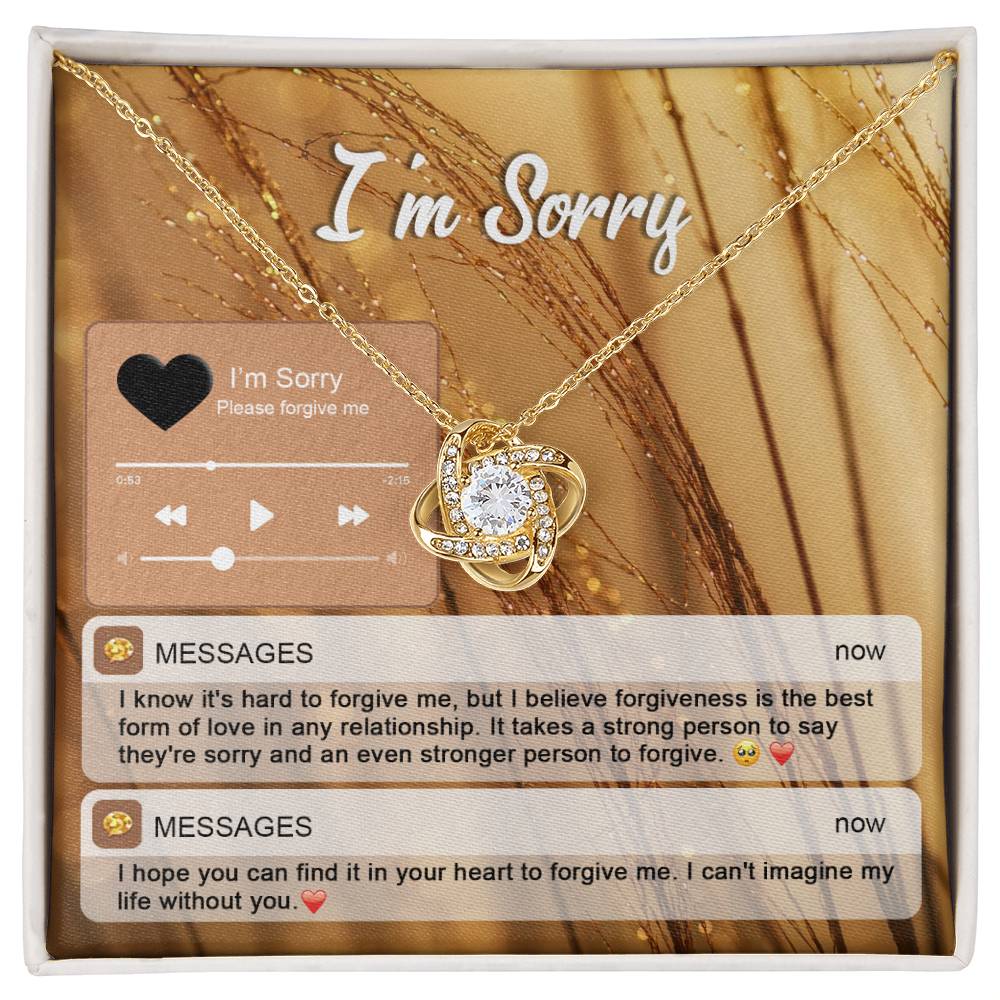 The "Sorry, Person To Forgive - Love Knot Necklace" features a gold finish and sparkling cubic zirconia crystals. It is presented on a card adorned with musical notes and icons that reads "I'm Sorry," along with heartfelt messages of apology and pleas for forgiveness.