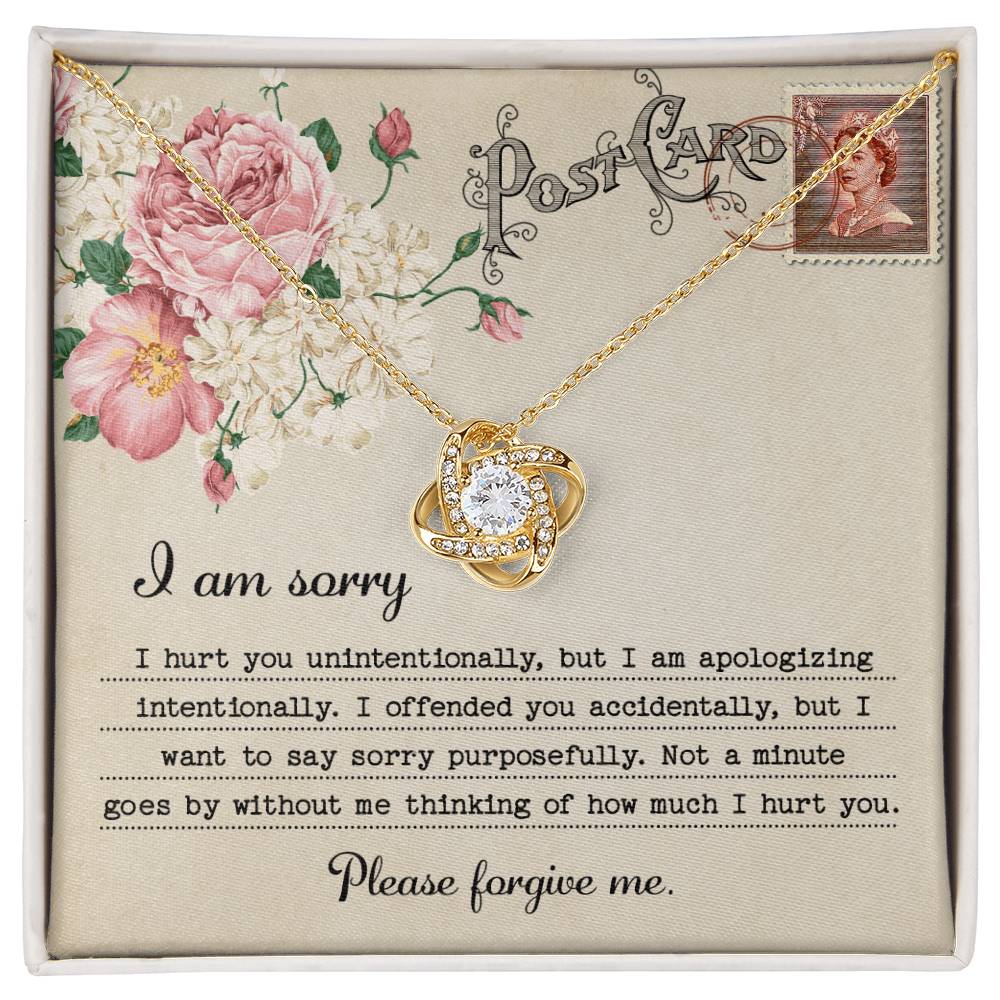 The "Sorry-Apologizing Intentionally - Love Knot Necklace," featuring a 14k white gold intertwined heart pendant, is beautifully presented on a card with a floral design that includes an apology note expressing heartfelt remorse and asking for forgiveness.