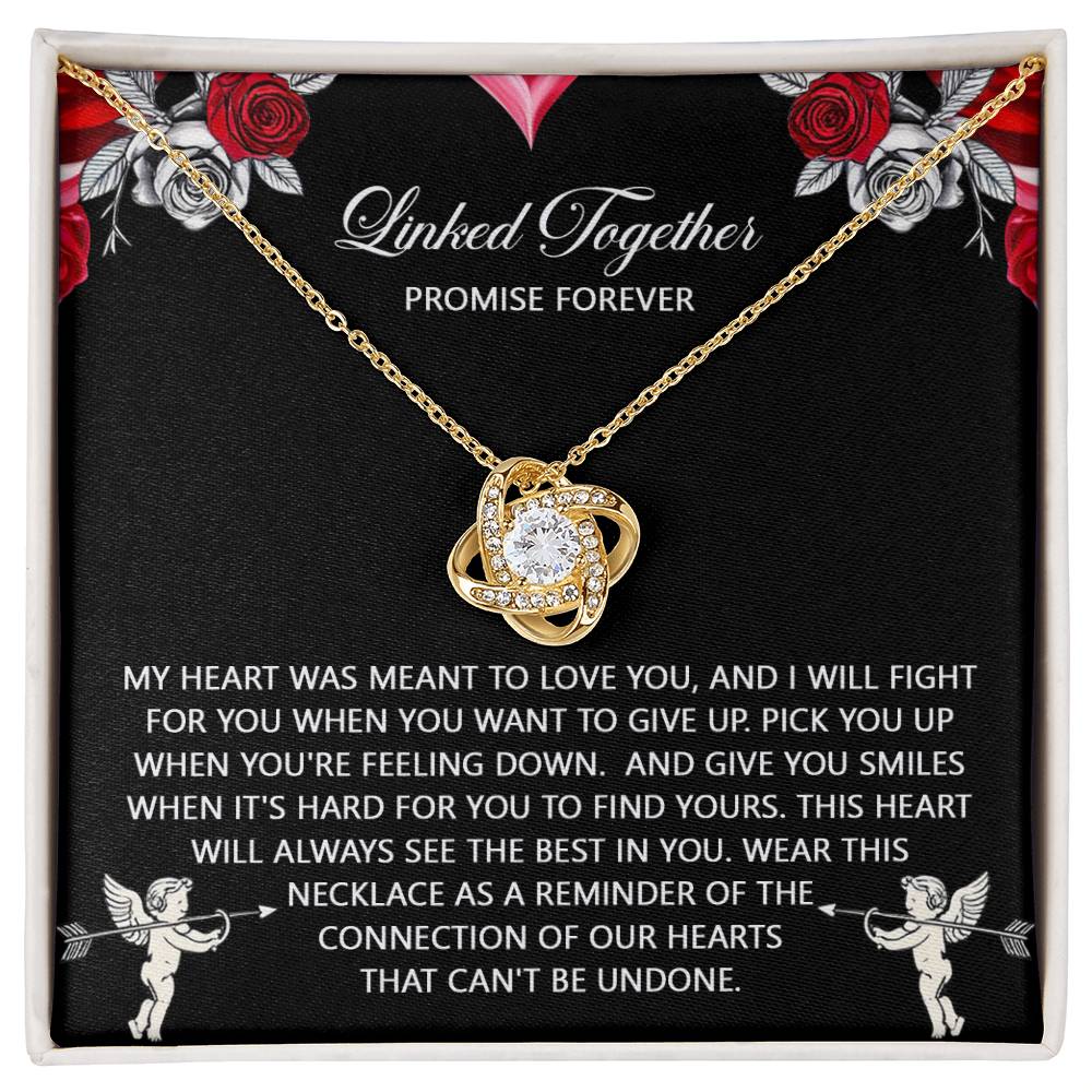 The Soulmate-To Find Yours Love Knot Necklace, featuring cubic zirconia crystals, comes on a sentimental card beautifully surrounded by decorative roses and cherubs, elegantly finished in lustrous gold.