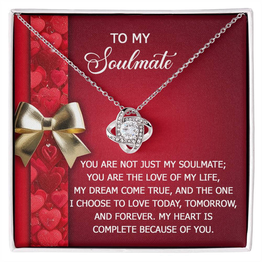 The Soulmate-Because Of You - Love Knot Necklace, featuring interlinked rings and shimmering cubic zirconia, is displayed on a decorative card with a heartfelt message for your soulmate.