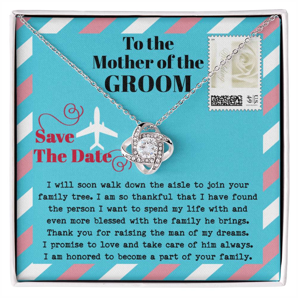 A silver *To Mom Of Groom, Down The Aisle - Love Knot Necklace* with a diamond knot pendant is displayed in a gift box. Adorned with cubic zirconia crystals, the necklace radiates elegance. The box has a message to the "Mother of the Groom" expressing gratitude and a commitment to caring for her son.