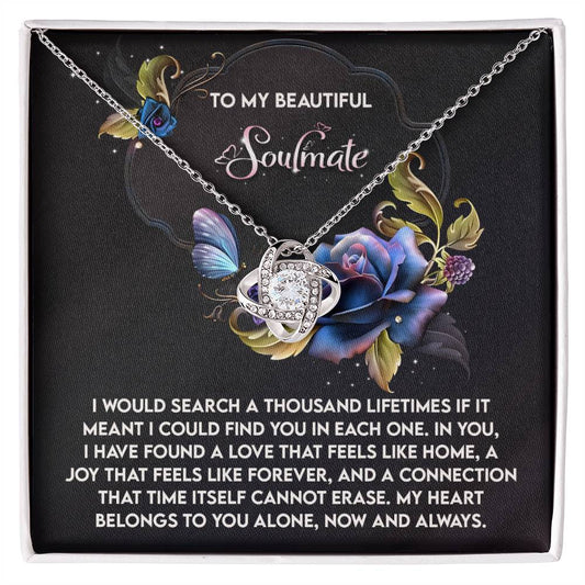 The Soulmate-Like Home Love Knot Necklace features an intertwined knot design with cubic zirconia crystals on a floral background, displaying a sentimental message for your soulmate.