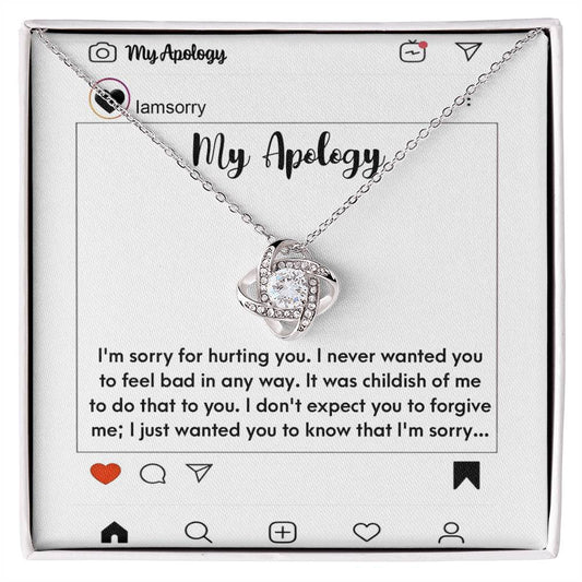 The "Sorry-My Apology - Love Knot Necklace," featuring a white gold finish and sparkling cubic zirconia crystals, is elegantly displayed in a box. The background includes an emotional apology message presented as a simulated social media post.