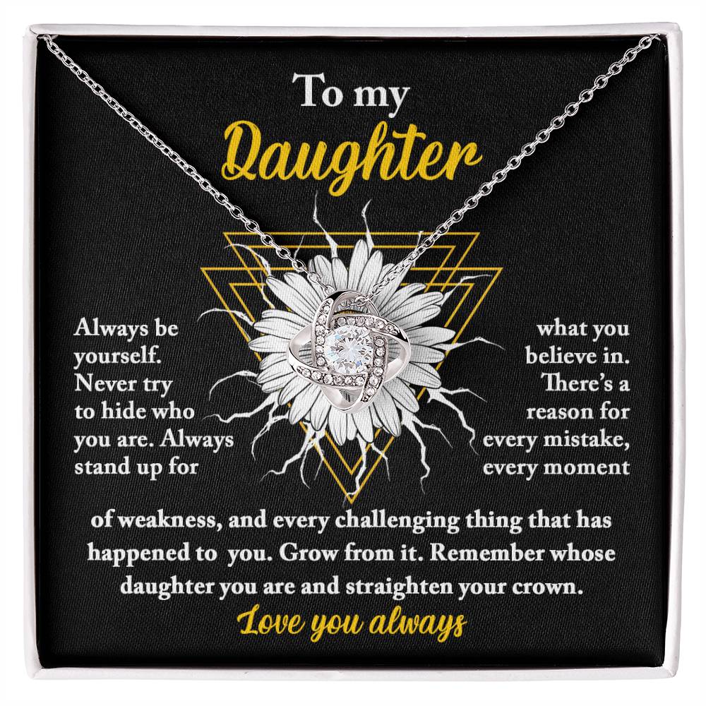 A personalized gift, this "To Daughter, Be Yourself - Love Knot Necklace" features a pendant encrusted with cubic zirconia crystals, nestled in a gift box. The box lid displays a heartfelt message addressed to "My Daughter," showcasing motivational and supportive text alongside a sunflower graphic.