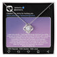 A stunning "Sorry-Hurt You Badly - Love Knot Necklace" in 14k white gold, adorned with cubic zirconia crystals, is displayed in front of a printed Instagram post that includes an apology message and hashtags like #sorry and #iloveyou.