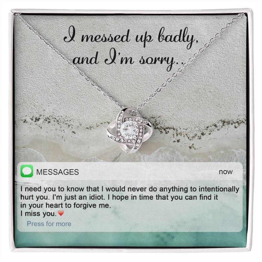 The "Sorry-Just An Idiot - Love Knot Necklace" features a heart-shaped pendant adorned with cubic zirconia crystals, presented on a card inscribed with "I messed up badly, and I'm sorry." It comes complete with a heartfelt text message expressing deep remorse and seeking forgiveness.