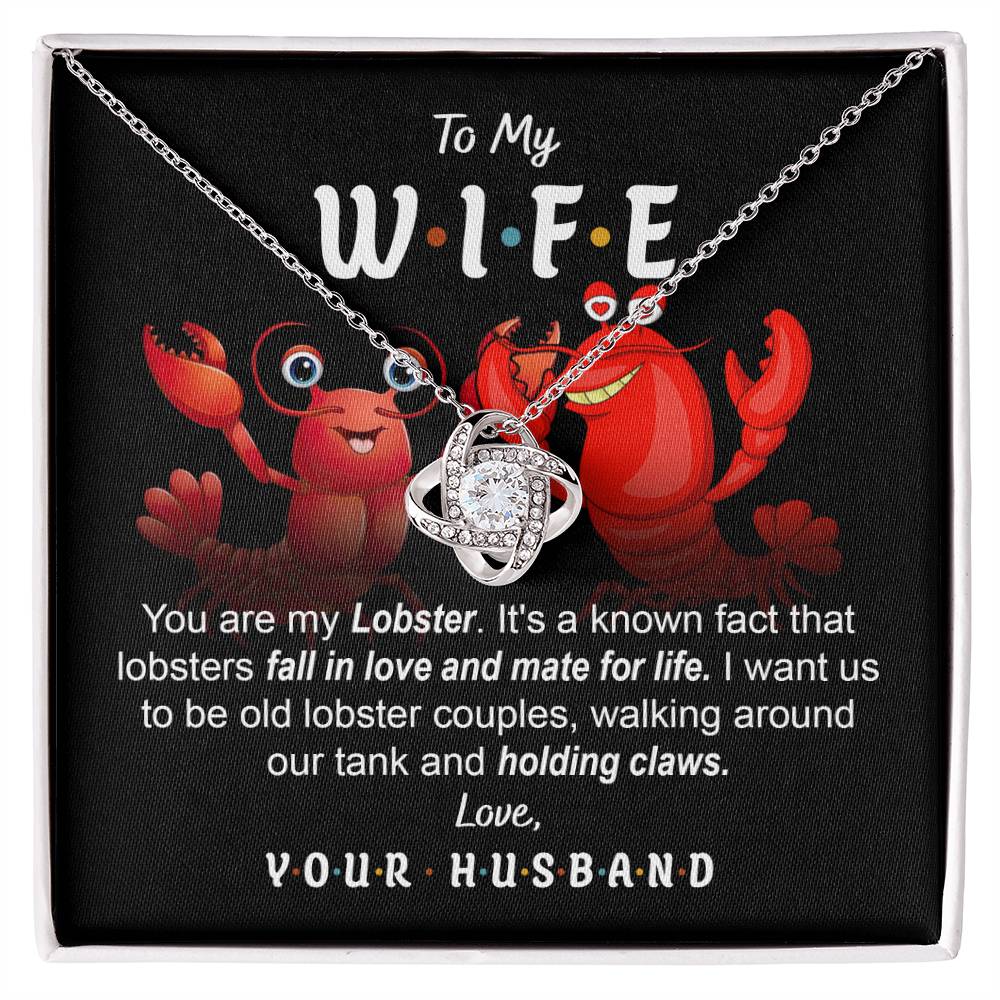 To Wife, Old Lobster Couples - Love Knot Necklace with a heart pendant displayed on a card featuring two cartoon lobsters and a message to a wife, discussing lifelong lobster mates and expressing love from a husband. The necklace sparkles with cubic zirconia crystals, symbolizing the unbreakable bond of your love.