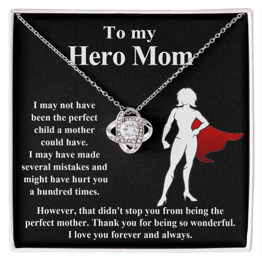 A To Mom, The Perfect Mother - Love Knot Necklace with a heart-shaped pendant on a display card featuring a silhouette of a mom superhero, with an emotional message titled "To my hero mom.
