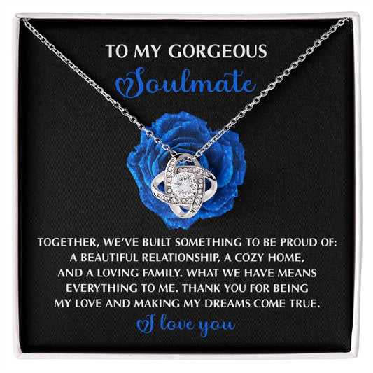 The Soulmate-Dreams Come True - Love Knot Necklace features cubic zirconia set in white gold, displayed on a card with a heartfelt message to a soulmate against a blue rose background.