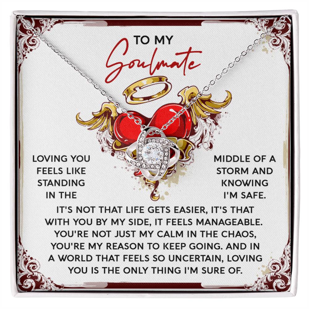 The Soulmate-Keep Going - Love Knot Necklace features a heart and swirl pendant with sparkling Cubic Zirconia Crystals, resting on a "To My Soulmate" card adorned with ornamental designs and a heart illustration, creating an ideal personalized gift for romantic occasions.