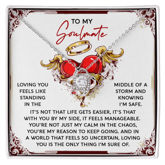 The Soulmate-Keep Going - Love Knot Necklace features a heart and swirl pendant with sparkling Cubic Zirconia Crystals, resting on a "To My Soulmate" card adorned with ornamental designs and a heart illustration, creating an ideal personalized gift for romantic occasions.