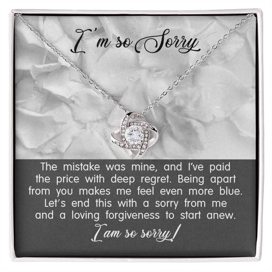 A Sorry-With Deep Regret - Love Knot Necklace with a white gold finish and a pendant on a card that says "I'm so Sorry." The card contains an apology message expressing regret and a plea for forgiveness.