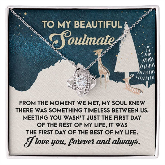 An elegant and meaningful gift, the Soulmate- Between Us - Love Knot Necklace features shimmering cubic zirconia crystals on a card that reads, "To my beautiful soulmate," along with a heartfelt message against a winter-themed background illustration.