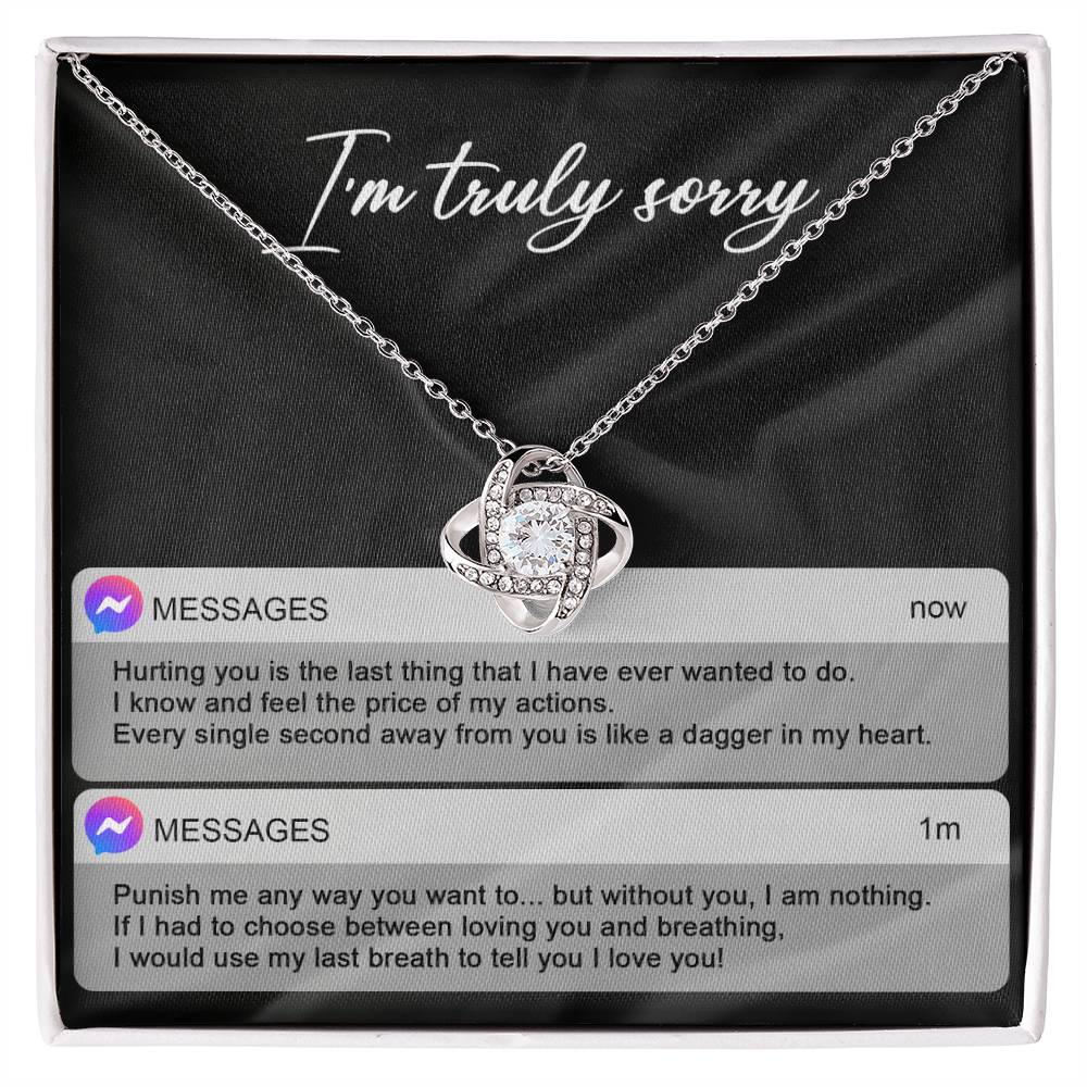 The Sorry-Away From You - Love Knot Necklace features interwoven heart pendants adorned with cubic zirconia crystals, and comes in a box with "I'm truly sorry" inscribed above. Accompanying the necklace are two text message excerpts expressing regret and love, making it an ideal personalized gift.