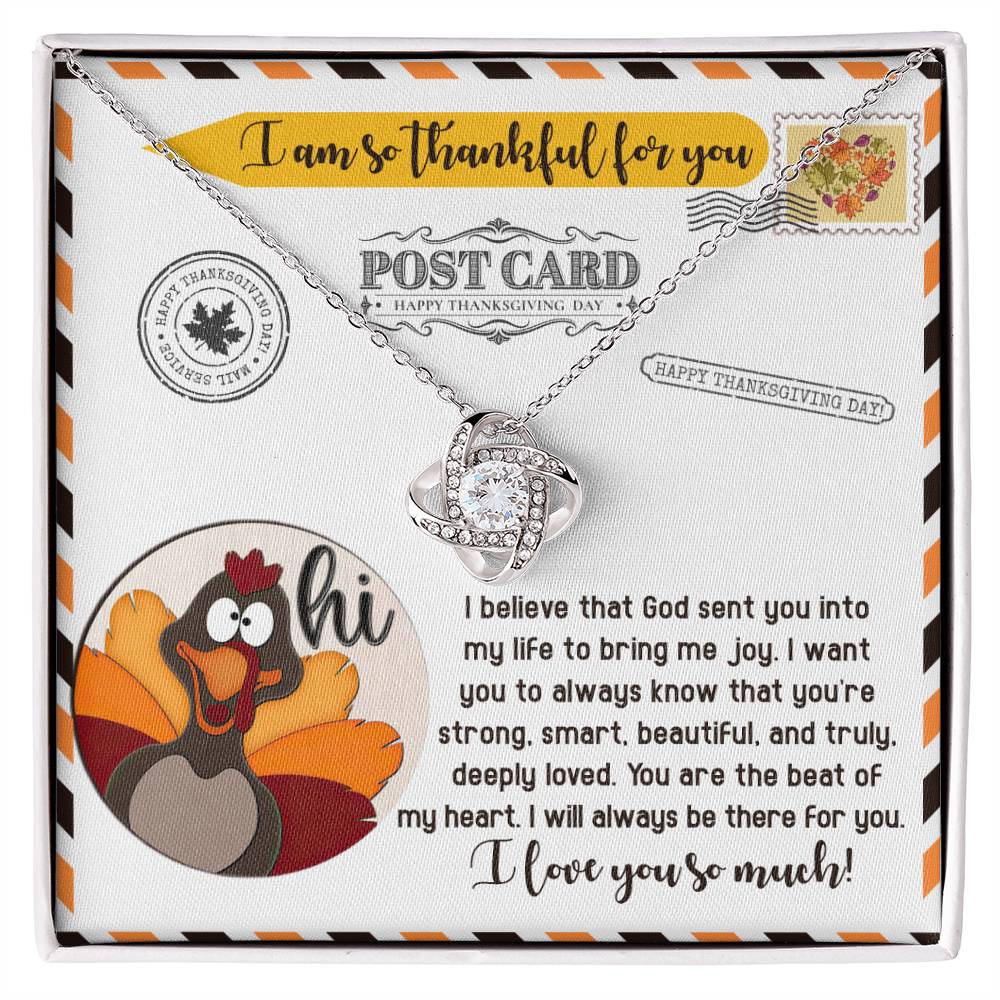 A Thanksgiving-themed card featuring a turkey illustration and heartfelt message, accompanied by the Thanksgiving-The Beat - Love Knot Necklace, which includes a heart pendant adorned with cubic zirconia and finished in lustrous gold.