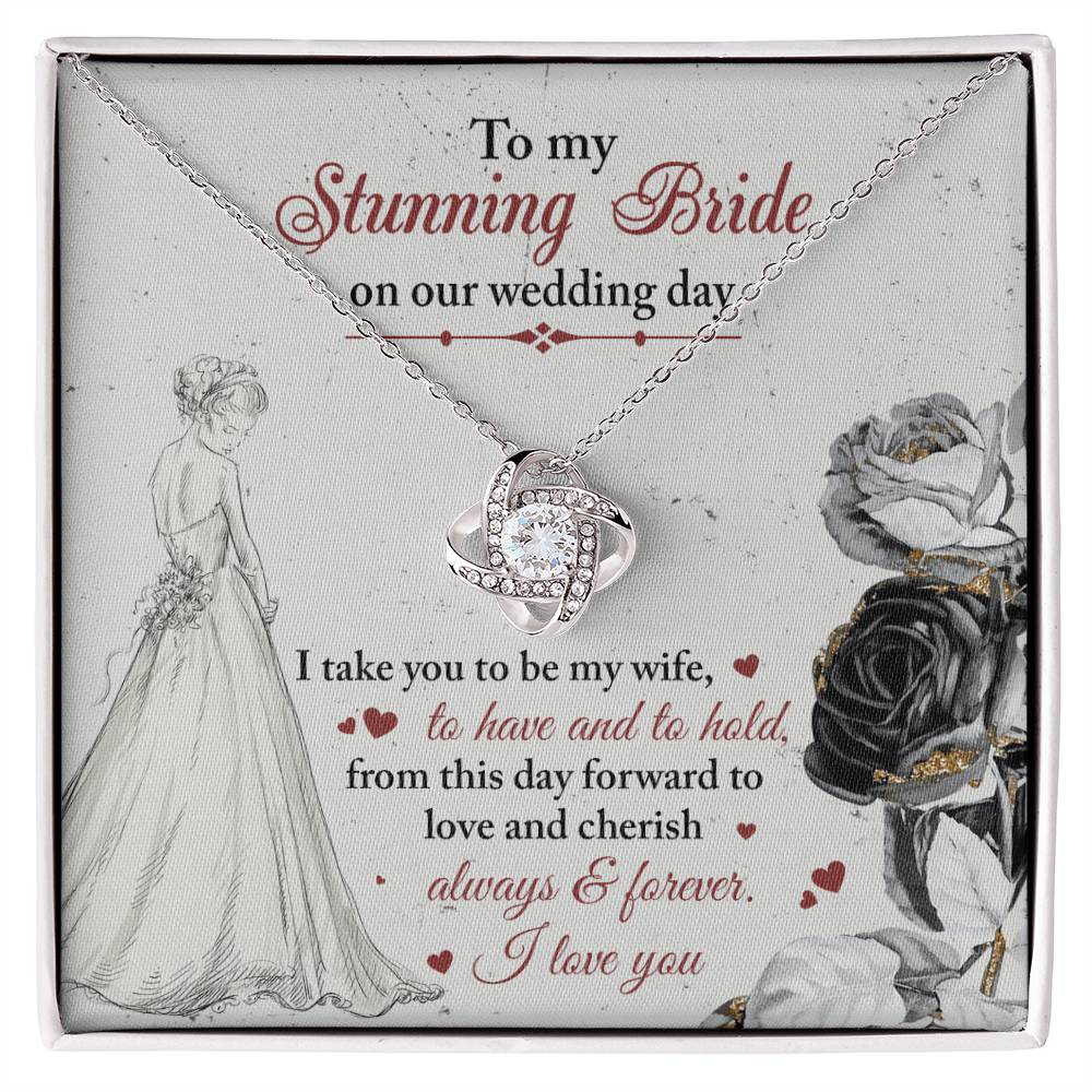 A To My Bride, Be My Wife - Love Knot Necklace with a pendant adorned in cubic zirconia crystals is displayed against a background featuring a bride illustration and a heartfelt wedding message.