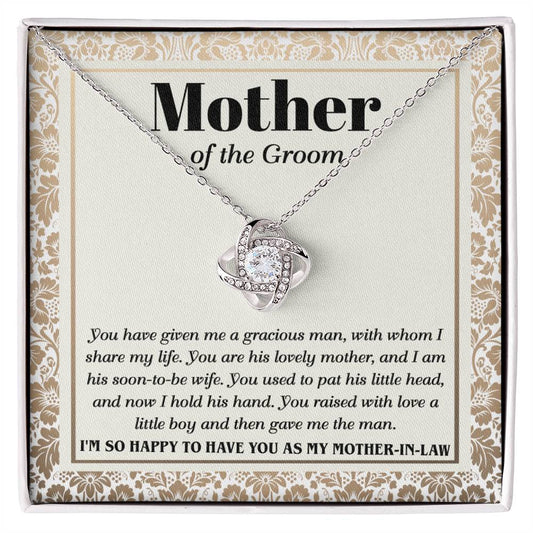 A "To Mother-In-Law, To Have You - Love Knot Necklace" with a heart-shaped pendant adorned with cubic zirconia crystals on a card labeled "Mother of the Groom" with a loving message expressing gratitude from the groom.