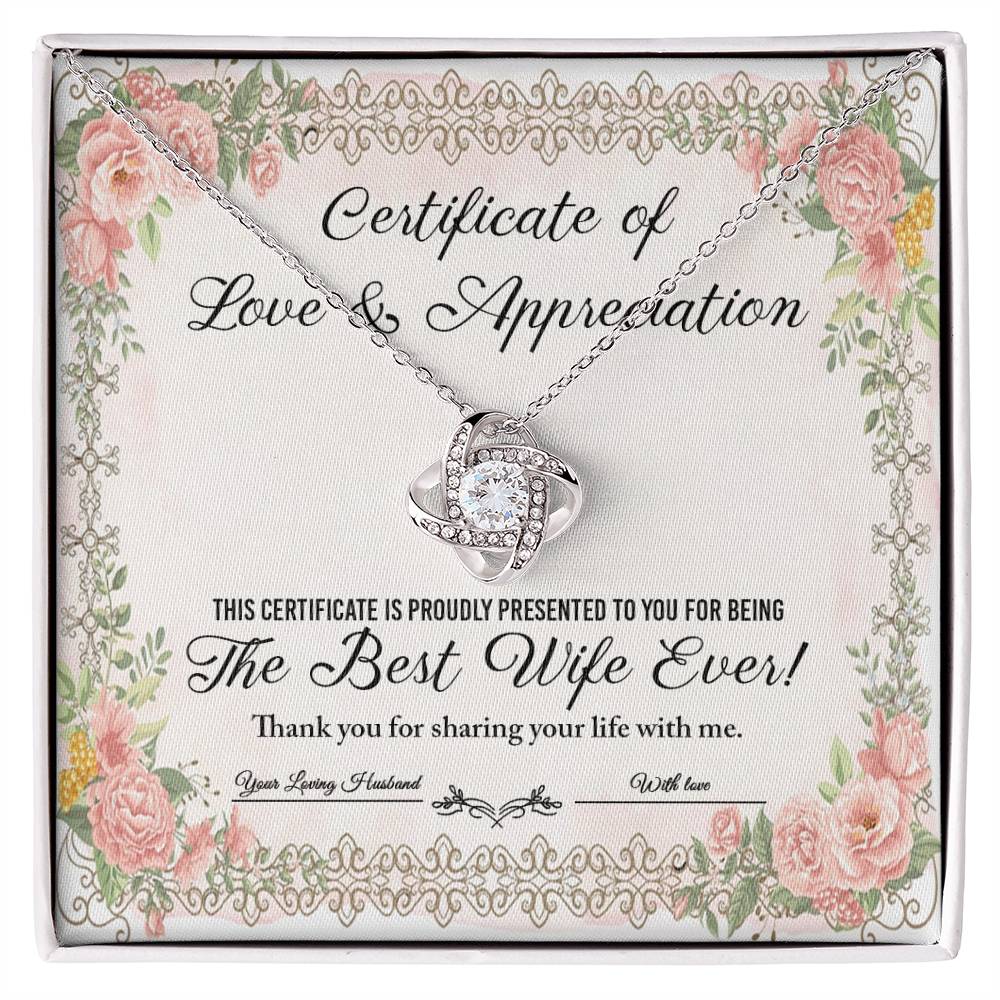 The "To Wife, Love & Appreciation - Love Knot Necklace" features a heart-shaped pendant elegantly displayed over a "Certificate of Love & Appreciation," expressing gratitude for being "The Best Wife Ever!" The necklace showcases a gold finish with sparkling cubic zirconia crystals, and the certificate is beautifully adorned with floral borders.