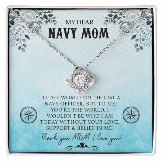 A "My Dear Navy Mom, To The World You're Just A Navy Officer" Love Knot Necklace with a heart-shaped pendant adorned with cubic zirconia crystals inside a gift box with a sentimental message addressed to a "navy mom," expressing personal gratitude and love from ShineOn Fulfillment.