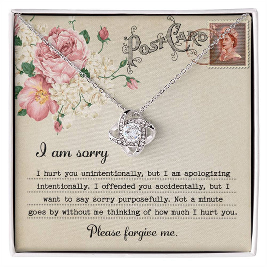 The "Sorry-Apologizing Intentionally - Love Knot Necklace," featuring a 14k white gold intertwined heart pendant, is beautifully presented on a card with a floral design that includes an apology note expressing heartfelt remorse and asking for forgiveness.