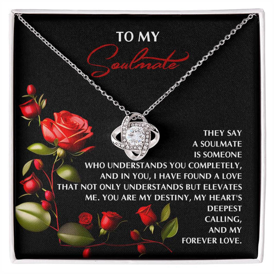 The Soulmate-Deepest Calling - Love Knot Necklace showcases a silver pendant elegantly placed in a rose-adorned box, complemented by a heartfelt message about soulmates, making it a timeless personalized gift.