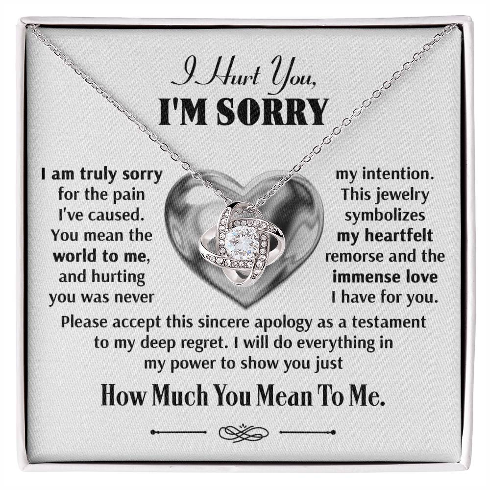 The Sorry-Sincere Apology - Love Knot Necklace features an intertwined heart pendant adorned with sparkling cubic zirconia crystals, elegantly displayed on a card that reads: "I hurt you, I'm sorry," followed by a heartfelt apology message expressing deep regret, sincere remorse, and immense love.