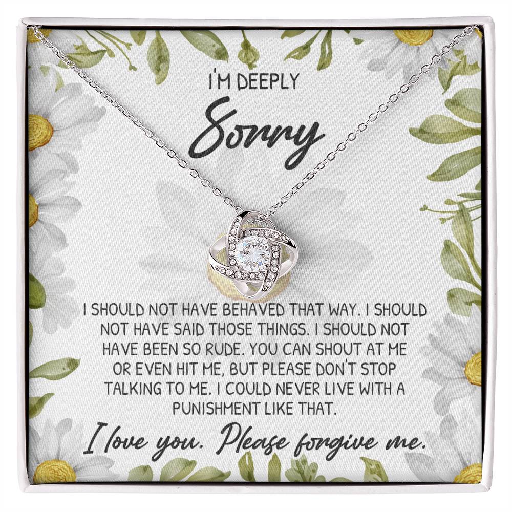 The Sorry-Please Don't Top - Love Knot Necklace features a pendant with intertwined loops and cubic zirconia crystals, elegantly presented on a floral-patterned card that includes an apology message.