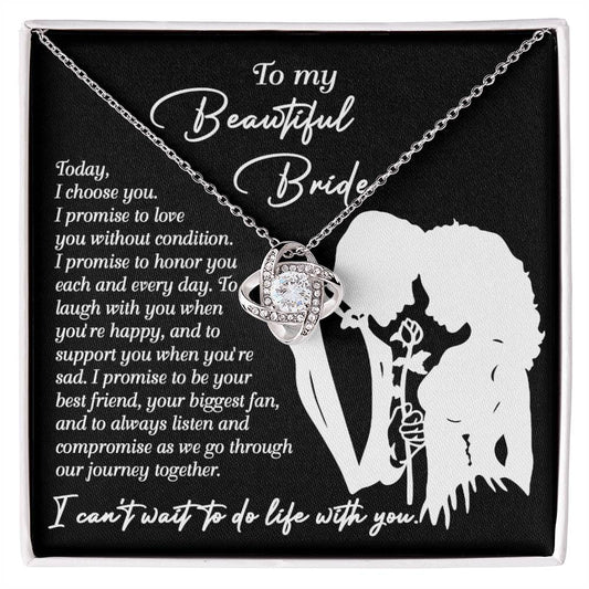 A To My Beautiful Bride, I Choose You - Love Knot Necklace with an intertwined design is displayed in a box. The box has a message to a bride expressing love and promises to honor, laugh, support, and be by her side through their journey together. The necklace features sparkling cubic zirconia crystals, making it a perfect personalized gift.