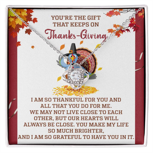 The Thanksgiving-Always Be Close - Love Knot Necklace, embellished with cubic zirconia crystals, is elegantly presented on a decorative card. With a charming turkey illustration and a message of gratitude, it makes an ideal personalized gift for someone special this festive season.