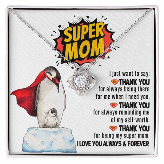 A "To Mom, Super Mom" themed love knot necklace with a heart-shaped pendant inside a gift box, featuring a printed message expressing gratitude and affection, adorned with a cartoon penguin graphic.