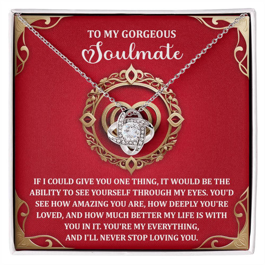 On a vibrant red backdrop, the Soulmate-Through My Eyes Love Knot Necklace is adorned with sparkling cubic zirconia crystals and conveys a heartfelt message about love and appreciation for a soulmate, making it a truly personalized gift that embodies your deep connection.