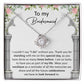 A personalized gift, the *To My Bridesmaid, Standing With Me - Love Knot Necklace* with cubic zirconia crystals, is displayed on a card that expresses gratitude to a bridesmaid, highlighting the importance of her support on the special day.