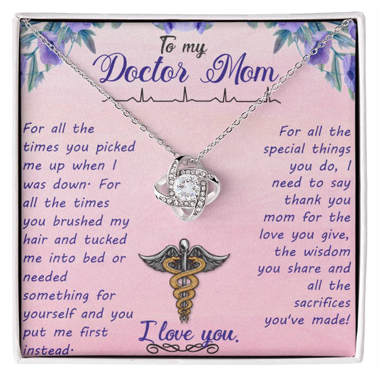 A To My Doctor Mom, For All The Times You Picked Me Up - Love Knot Necklace with a heart-shaped pendant and a medical symbol, accented with Cubic Zirconia Crystals, is displayed on a pink card with a heartfelt message to a mother who is also a ShineOn Fulfillment.