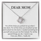 A silver heart-shaped pendant necklace adorned with cubic zirconia crystals and the Dear Mom, For All The Times You Picked Me Up - Love Knot Necklace by ShineOn Fulfillment displayed in a gift box.