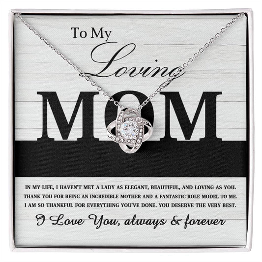 A To Mom, Loving As You - Love Knot Necklace with a heart-shaped pendant encrusted with cubic zirconia, displayed over a message for "mom" expressing love and gratitude.