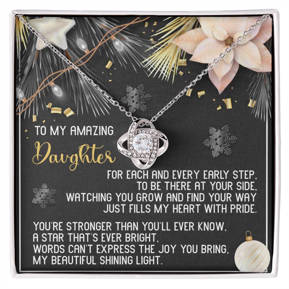 This Daughter-Shining Light - Love Knot Necklace serves as a personalized gift, featuring a star pendant on a gift card with a heartfelt message to your daughter. It is adorned with cubic zirconia crystals, and the background beautifully displays decorative snowflakes and pine branches.