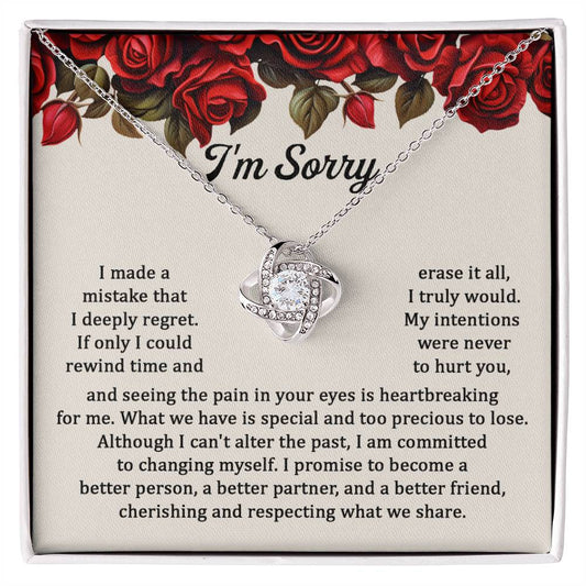 The "Sorry, Precious To Lose - Love Knot Necklace," adorned with cubic zirconia crystals, is displayed on a card featuring an apology message set against a background of red roses. The message expresses regret and a commitment to change.