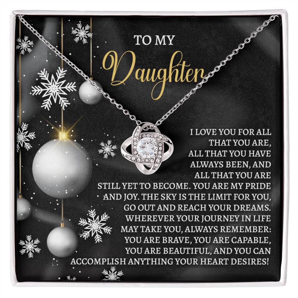 The Daughter-Pride And Joy - Love Knot Necklace features a heart-shaped pendant set against a snowflake background. It includes the text, "To my Daughter," along with an inspirational message about love, pride, and encouragement to follow her dreams. Personalized and adorned with cubic zirconia, this keepsake is a timeless treasure she'll always cherish.