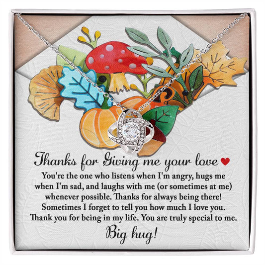 The Thanksgiving-Big Hug - Love Knot Necklace comes presented on a card with a heartfelt message and is beautifully adorned with illustrations of leaves, mushrooms, and pumpkins. Featuring a gold finish and sparkling cubic zirconia, it makes for the perfect keepsake for someone special.