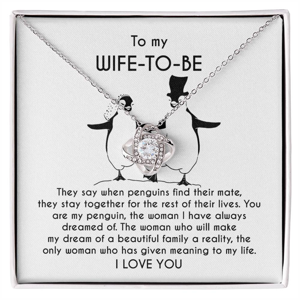 A silver *To Wife-to-be, My Penguin - Love Knot Necklace* with a flower-like pendant is displayed on a jewelry card. The card contains a message to a "Wife-To-Be" featuring a heartfelt dedication and illustrations of two penguins.