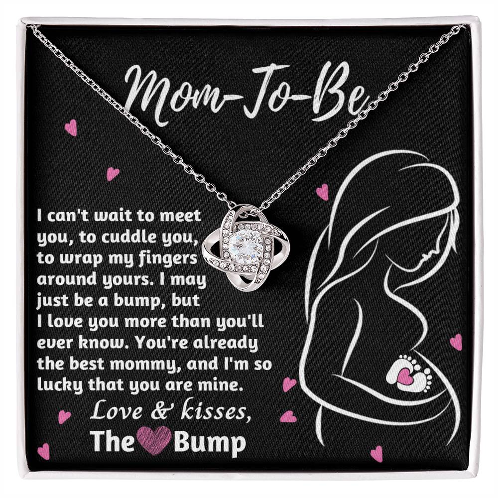 A To Mama To Be, The Best Mommy - Love Knot Necklace pendant, placed beside a sentimental message to an unborn child from 'the bump', on a black background with pink hearts.