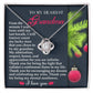 The Grandma-Eternal Sunflower - Love Knot Necklace, featuring a white gold finish and a sparkling cubic zirconia pendant, is elegantly packaged in a box. It includes a heartfelt message to a grandmother, adorned with ornaments and the touching phrase "I love you.
