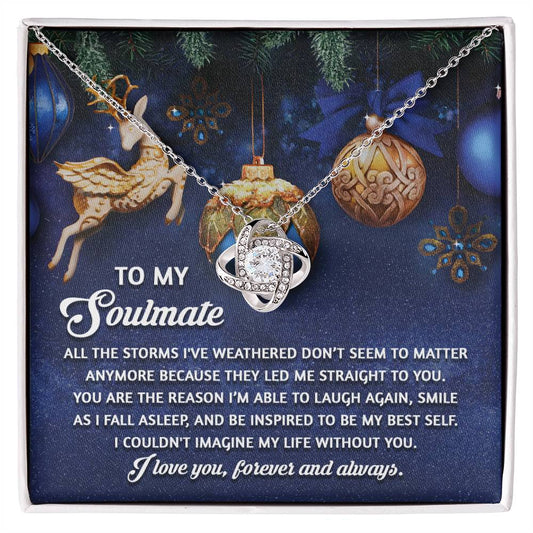 The Soulmate-Straight To You - Love Knot Necklace, elegantly crafted from 14k white gold and adorned with shimmering cubic zirconia crystals, comes in a gift box with a heartfelt message for your soulmate and is beautifully set against a backdrop of deer and hanging ornaments.