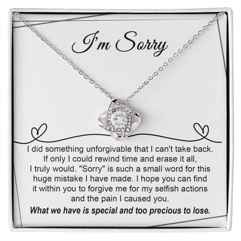 The Sorry-Breaking My Heart - Love Knot Necklace, featuring a gold finish and embellished with sparkling cubic zirconia crystals, is presented on a heartfelt message card that expresses deep regret for a mistake and seeks forgiveness.