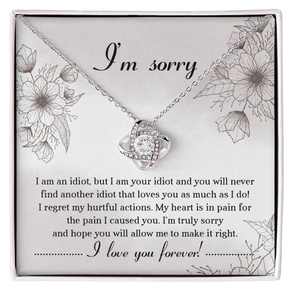 The Sorry-For The Pain - Love Knot Necklace is a personalized gift featuring a love knot pendant adorned with cubic zirconia crystals, presented on a card with an apology message expressing regret and a heartfelt plea for forgiveness, ending with "I love you forever!