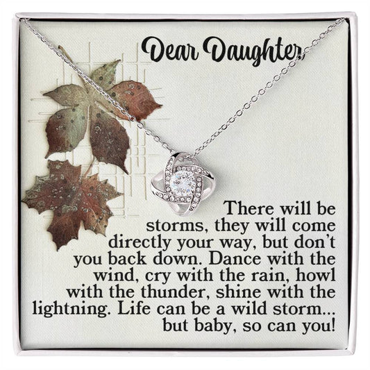 The Daughter-With The Thunder - Love Knot Necklace showcases an intertwined design in a box, finished elegantly in gold. It includes a motivational message titled "Dear Daughter" along with an image of leaves, all sparkling with cubic zirconia accents.