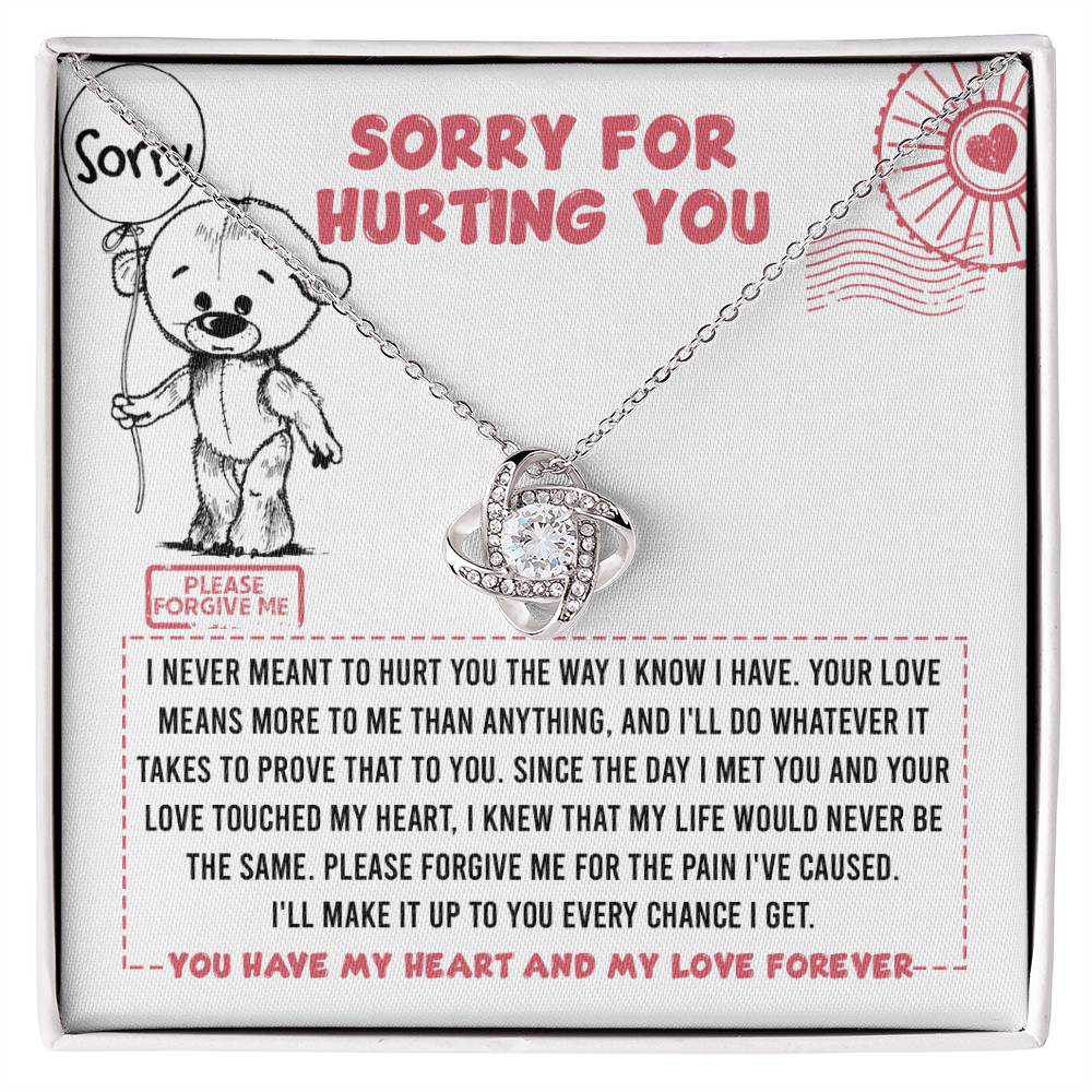 The "Sorry-Every Chance - Love Knot Necklace" features a stunning intertwined design adorned with cubic zirconia crystals. It is beautifully displayed on a card that includes an apology message reading "Sorry for hurting you," along with a heartfelt note and an adorable drawing of a bear holding a sign.