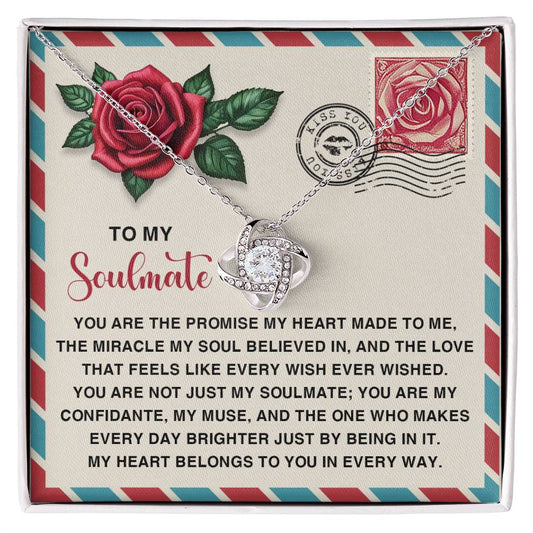 The Soulmate-Made To Me Love Knot Necklace features a heart design with sparkling cubic zirconia crystals, presented on a card titled "To My Soulmate," complete with rose graphics and a romantic message.