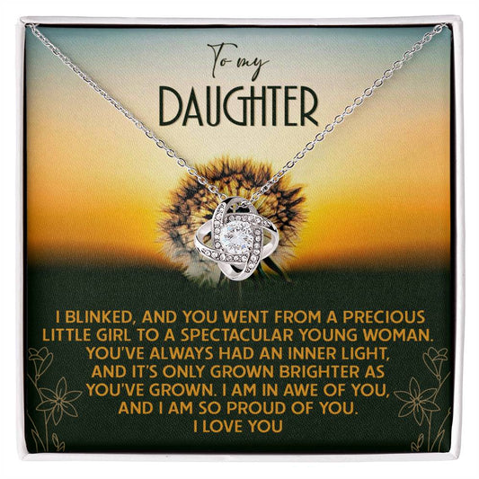 The Daughter-Grown Brighter - Love Knot Necklace, crafted in 14k white gold and adorned with cubic zirconia crystals, is elegantly displayed on a box featuring a touching message from a parent to their daughter, conveying pride and love.