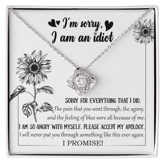 The Sorry-Feeling Of Blue - Love Knot Necklace, crafted from 14k white gold with a heart-shaped pendant adorned with cubic zirconia crystals, is displayed in a box containing an apology message, "I'm sorry, I am an idiot," along with additional text expressing regret for causing pain and a promise to not repeat the hurt.